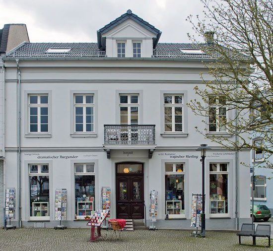 Die Fassade der lesezeit am Kirchplatz in Sinzig, mit Büchertischen vor der Tür
